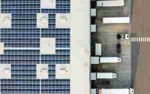 Aerial view of an industrial warehouse roof and loading docks with trailers